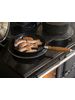 Esse Ironheart with sausages in a pan on hot plate